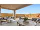 Relaxing covered patio featuring outdoor seating, a dining table, and a landscaped backyard for comfortable outdoor living at 15627 W Williams St, Goodyear, AZ 85338