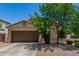 Single-story home with a brown garage door and desert landscaping at 16091 W Moreland St, Goodyear, AZ 85338