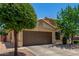 Charming home exterior featuring a two-car garage and mature landscaping at 16091 W Moreland St, Goodyear, AZ 85338