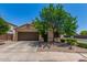 Inviting single-story home with a two-car garage and manicured front yard landscaping under a bright blue sky at 16091 W Moreland St, Goodyear, AZ 85338