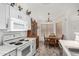 White kitchen featuring ample counter space, dining area, and brick floor at 16091 W Moreland St, Goodyear, AZ 85338