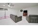Basement featuring a gray sectional sofa, flat screen television, and ceiling fan at 1712 E Fairfield St, Mesa, AZ 85203
