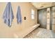 Modern bathroom with wood paneling, rainfall shower, herringbone tiling, and sleek tiled bench seating at 1712 E Fairfield St, Mesa, AZ 85203