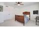 Bright bedroom featuring a ceiling fan, neutral carpet, and a decorative wood bed frame at 1712 E Fairfield St, Mesa, AZ 85203