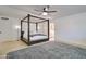 Bright bedroom features a modern four-poster bed, ceiling fan, and light wood flooring at 1712 E Fairfield St, Mesa, AZ 85203