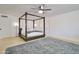 Bright bedroom features a modern four-poster bed, ceiling fan, and light wood flooring at 1712 E Fairfield St, Mesa, AZ 85203