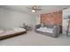 Large carpeted bedroom showcases two beds and a charming brick accent wall at 1712 E Fairfield St, Mesa, AZ 85203