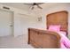 Bright bedroom with a decorative wood bedframe, lovely ceiling fan, and ample closet space at 1712 E Fairfield St, Mesa, AZ 85203