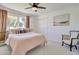 Cozy bedroom with a ceiling fan, a comfortable bed, and a classic chair with an antique design at 1712 E Fairfield St, Mesa, AZ 85203
