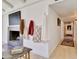 Hallway with coats hung on wall leading to a living room with a fire place at 1712 E Fairfield St, Mesa, AZ 85203