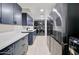Efficient laundry room with blue cabinets, white countertops, stacked washer/dryer units, and refrigerator at 1712 E Fairfield St, Mesa, AZ 85203