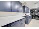 A modern laundry room with navy cabinets, stainless steel washer dryer, and quartz countertops at 1712 E Fairfield St, Mesa, AZ 85203
