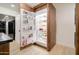 Pantry with floor-to-ceiling wood cabinetry, open door refrigerator, and black kitchen appliances at 1712 E Fairfield St, Mesa, AZ 85203