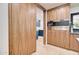 Modern pantry with wood cabinets and built-in microwave oven and blue room access at 1712 E Fairfield St, Mesa, AZ 85203
