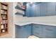 Updated pantry with blue cabinetry, quartz countertops, and built-in wooden shelving at 1712 E Fairfield St, Mesa, AZ 85203