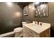 Elegant powder room with dark walls, designer mirror, and a decorative carved wood vanity at 1712 E Fairfield St, Mesa, AZ 85203