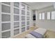 Well-organized walk-in closet with built-in storage, frosted-glass cabinets, and a comfortable bench at 1712 E Fairfield St, Mesa, AZ 85203