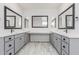 Bathroom with double vanity sinks, white countertops, and gray cabinets at 17322 W Puget Ave, Waddell, AZ 85355