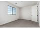 Bedroom featuring neutral walls and carpet with a large window and door at 17322 W Puget Ave, Waddell, AZ 85355