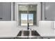 Kitchen sink with modern fixtures, window, and view to the backyard at 17322 W Puget Ave, Waddell, AZ 85355