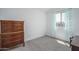 Bright bedroom featuring a large window and an antique wooden dresser at 1799 N 209Th Ave, Buckeye, AZ 85396