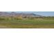 Expansive golf course with meticulously manicured greens and stunning mountain views in the background at 1799 N 209Th Ave, Buckeye, AZ 85396