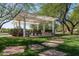 Charming picnic area with a covered pergola, stone seating, and lush landscaping for outdoor gatherings at 1799 N 209Th Ave, Buckeye, AZ 85396