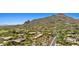 Picturesque aerial view of homes scattered across a desert landscape against a backdrop of rugged mountains at 2304 Fox Tail Trl, Carefree, AZ 85377