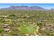 Scenic aerial view of a lush community, with a well-maintained golf course and majestic mountain backdrop at 2304 Fox Tail Trl, Carefree, AZ 85377