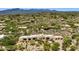 Aerial view of a home nestled among desert landscape with cacti and desert foliage, set against mountain backdrop at 2304 Fox Tail Trl, Carefree, AZ 85377