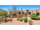Neutral home with a brick-lined entrance path and gate plus mature desert vegetation at 2304 Fox Tail Trl, Carefree, AZ 85377