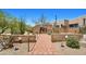 Brick-lined walkway leading to a neutral home with desert landscaping and a gated courtyard at 2304 Fox Tail Trl, Carefree, AZ 85377