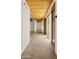 Hallway featuring wooden beam ceilings, tile floors, and natural light from nearby windows at 2304 Fox Tail Trl, Carefree, AZ 85377
