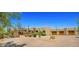 Expansive desert home featuring a landscaped yard, walled entrance, and a three-car garage with wooden doors at 2304 Fox Tail Trl, Carefree, AZ 85377