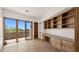 Bright office space with built-in wooden shelving, desk and drawers, complemented by large sliding glass doors at 2304 Fox Tail Trl, Carefree, AZ 85377