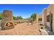 Expansive patio featuring an outdoor fireplace, desert landscaping, and natural stone accents at 2304 Fox Tail Trl, Carefree, AZ 85377