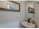 A half bath featuring a modern sink, large mirrors, and decorative accents at 2540 N 148Th Dr, Goodyear, AZ 85395