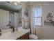 Bathroom with a window and featuring a single sink vanity, toilet, decorative accents, and tub with shower at 2540 N 148Th Dr, Goodyear, AZ 85395