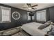 Inviting bedroom with dark gray walls, ceiling fan, modern clock, and a cozy dog bed at 2540 N 148Th Dr, Goodyear, AZ 85395