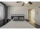 Comfortable bedroom featuring a decorative shiplap wall, ceiling fan, and ensuite bathroom with shower at 2540 N 148Th Dr, Goodyear, AZ 85395