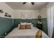 Stylish bedroom showcasing half painted wall, ceiling fan, window, and decorative wall art at 2540 N 148Th Dr, Goodyear, AZ 85395
