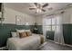 Well-lit bedroom showcasing half painted wall, ceiling fan, and decorative window with sheer curtains at 2540 N 148Th Dr, Goodyear, AZ 85395