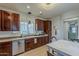 Beautiful kitchen featuring brown cabinets, stainless steel dishwasher, and dining area at 2540 N 148Th Dr, Goodyear, AZ 85395