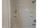 Bathroom showcasing a white tiled shower with built-in shelves, updated fixtures, and curtain rod at 2540 N 148Th Dr, Goodyear, AZ 85395