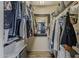 Walk-in closet with mirror, rods, shelving, and ample storage solutions for organizing clothes and accessories at 2540 N 148Th Dr, Goodyear, AZ 85395