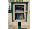 Community book exchange, painted green and tan, filled with multiple books for public borrowing at 2635 N El Dorado Pl, Chandler, AZ 85224