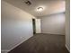 An empty bedroom with gray walls, carpet, and a closet is illuminated by a ceiling light at 2745 E Wood St, Phoenix, AZ 85040