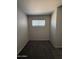 An empty bedroom with neutral walls and carpet features a window and is ready for furnishing at 2745 E Wood St, Phoenix, AZ 85040