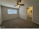 A bedroom featuring a ceiling fan, a window, carpet and view into attached bathroom at 2745 E Wood St, Phoenix, AZ 85040