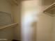 An interior shot of a walk-in closet with white walls, wooden shelves and an air vent at 2745 E Wood St, Phoenix, AZ 85040